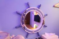 a round mirror hanging on a blue wall at Queen Love Homestay in Hualien City