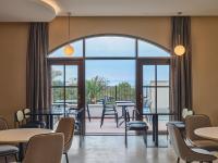 uma sala de espera com mesas e cadeiras e uma grande janela em Hundert Hills em Jeju