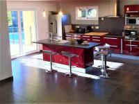 a kitchen with a red island with stools in it at Maison Vagnas, 4 pièces, 6 personnes - FR-1-382-176 in Vagnas