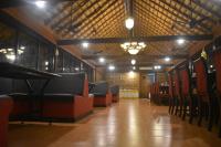 una sala d'attesa con sedie e lampadario a braccio di Ibex River Resort, Pollachi a Coimbatore
