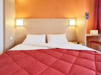 a bedroom with a large red bed with two pillows at Premiere Classe Orleans Ouest - La Chapelle St Mesmin in La Chapelle-Saint-Mesmin