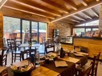 Un restaurante con mesas y sillas de madera y ventanas. en B&B Snow Village Roccaraso, en Roccaraso