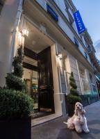 a dog sitting in front of a building at Hotel Splendor Elysées in Paris