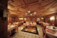 a dining room with tables and chairs and a chandelier at Hotel Chalet Alpenrose Bio Wellness Naturaktivhotel in Cogolo