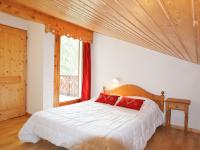 a bedroom with a bed with red pillows and a window at Appartement Samoëns, 3 pièces, 6 personnes - FR-1-624-103 in Samoëns