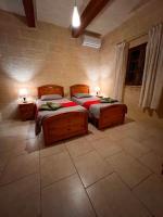 a bedroom with two beds and two lamps on tables at Ta’ Peppi Farmhouse in Qala
