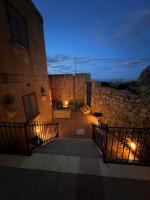 a building with a gate next to a building with lights at Ta’ Peppi Farmhouse in Qala