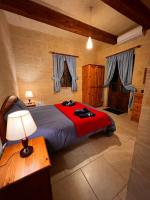 a bedroom with a large bed with a red blanket at Ta’ Peppi Farmhouse in Qala