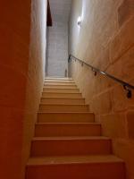 a staircase in a building with orange steps at Ta’ Peppi Farmhouse in Qala