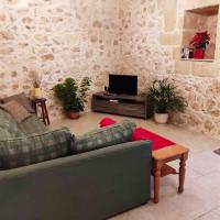 a living room with a couch and a tv at Ta’ Peppi Farmhouse in Qala