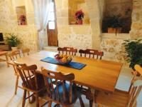 a wooden table with chairs and a bowl of fruit on it at Ta’ Peppi Farmhouse in Qala