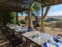 uma mesa longa com pratos azuis e óculos em Podere Spedalone em Pienza