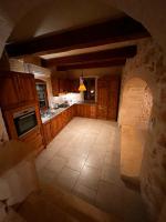 a large kitchen with wooden cabinets and a tile floor at Ta’ Peppi Farmhouse in Qala