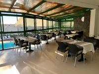 a restaurant with tables and chairs and a pool at Acapulco Ocean View in San Agustin