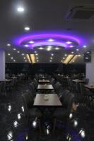 een eetkamer met tafels en stoelen en paarse verlichting bij Arhavi Resort Otel in Arhavi