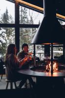 2 persone sedute a un tavolo di fronte a un camino di Magical Pond Nature Igloos a Ruka