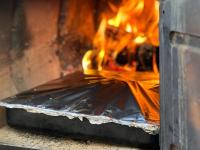 a fire is coming out of a stove at Klaarstroom Hotel in Klaarstroom