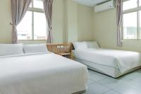 two beds in a room with two windows at Star-Moon B&amp;B Green Island in Green Island