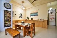 a dining room with a table and chairs and a clock at Piau Po 21 Inn in Taitung City