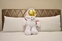a toy astronaut sitting on a bed with a gold spoon at Piau Po 21 Inn in Taitung City