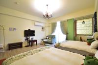 a hotel room with two beds and a television at Piau Po 21 Inn in Taitung City