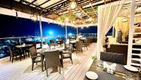 a restaurant with tables and chairs and a view of the city at Aurora Boutique Hotel Imphal in Imphal
