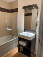 a bathroom with a sink and a mirror and a tub at ApartHotel Sainte-Marthe in Avignon