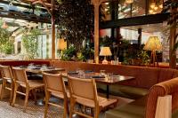 a restaurant with tables and chairs and plants at The Hoxton, Williamsburg in Brooklyn