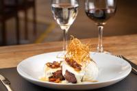 un plato de comida en una mesa con dos copas de vino en ArtHotel Transamerica Collection, en Porto Alegre