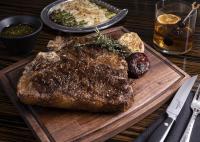 a steak on a wooden cutting board with a plate of food at Horseshoe Las Vegas in Las Vegas