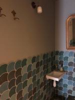 a bathroom with a sink and a large wall at Au bout du pré in Pézenas