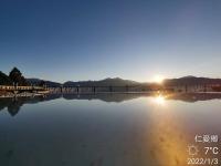 a bridge over a body of water with the sun setting at Naluwan Villa in Ren&#39;ai