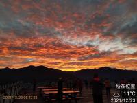 a group of people standing around a picnic table at sunset at Naluwan Villa in Ren&#39;ai