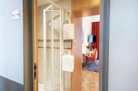 a bathroom with a glass door leading into a room at ACHAT Sternhotel Bonn in Bonn