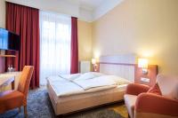 a hotel room with a bed and a desk and chairs at ACHAT Sternhotel Bonn in Bonn