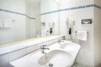 a white bathroom with a sink and a mirror at ACHAT Sternhotel Bonn in Bonn