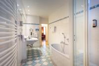a bathroom with a tub and a sink at ACHAT Sternhotel Bonn in Bonn