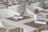 eine Reihe von weißen Tischen und Stühlen in einem Restaurant in der Unterkunft Hotel Egitarso Sul Mare in San Vito lo Capo