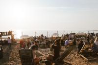 a crowd of people sitting in chairs on the beach at Surflogiet Gotland in Tofta