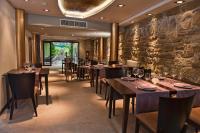 Hotel Palacio del Obispo في جراوس: مطعم بطاولات وكراسي وجدار حجري