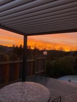 a table and chairs on a deck at sunset at Au-Doux-Altic chalet romantique avec JACUZZI ET SAUNA in Métabief