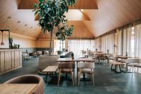 Un restaurante con techos de madera y mesas y sillas. en FeelViana Sport Hotel, en Viana do Castelo