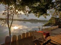 una panchina di legno seduta di fronte a un lago di Villa Liwonde - Cottage a Liwonde