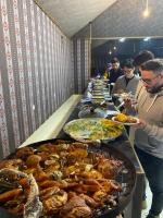 Katrina Rum camp في وادي رم: طابور طويل من الطعام مع بوفيه مفتوح حيث يتناول الناس الطعام