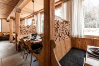 een eetkamer met een houten tafel en stoelen bij Typically Swiss Hotel Ermitage in Kandersteg