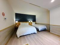 a bedroom with two beds and a black wall at Rainbow Hotel in Taipei