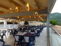 een patio met tafels, stoelen en verlichting bij Camping Mozziconaccio in Sainte-Lucie de Porto-Vecchio