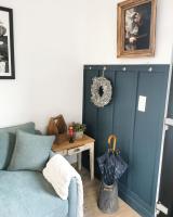 a living room with a blue couch and a table at Hydrangea Cottage Arras in Saint-Laurent-Blangy