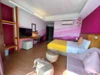 a bedroom with pink and purple walls and a bed at Tz Shin Resort Hostel in Kenting