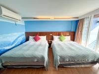 two beds sitting next to each other in a room at Tz Shin Resort Hostel in Kenting